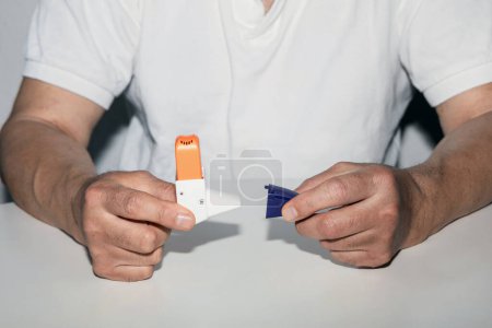 Téléchargez les photos : Un homme tenant un inhalateur d'asthme dans ses mains. Les inhalateurs de médicaments contre l'asthme sur fond blanc. Maladie pulmonaire. - en image libre de droit