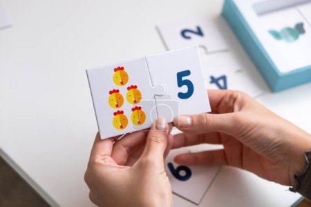 Photo for Math puzzle for young children. Two cards in a woman's hand. High quality photo - Royalty Free Image