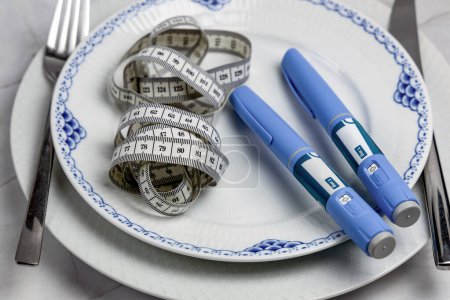Photo for Ozempic Insulin injection pen or insulin cartridge pen for diabetics on a white plate. Medical equipment for diabetes parients. - Royalty Free Image