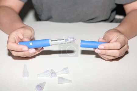 Female hands holding an insulin pen. Ozempic Insulin injection pen or insulin cartridge pen for diabetics. Medical equipment for diabetes parients. 