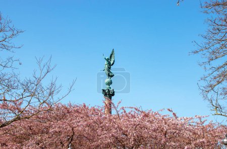 Photo for Copenhagen. Spring. Statue of ancient goddess Victoria with palm branch in hand at Langelinie Park in Copenhagen, Denmark. Cherry blossom in urban park. Sakura Festival. - Royalty Free Image