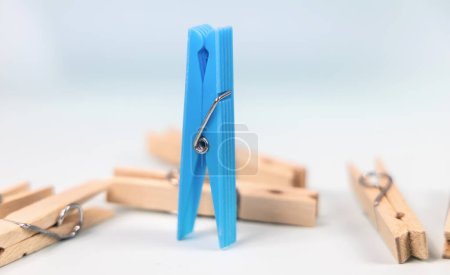 Photo for Blue clothespin on the background of ordinary wooden clothespins. The concept of being different, gender issue, standing out from the crowd, vision of man and woman. - Royalty Free Image