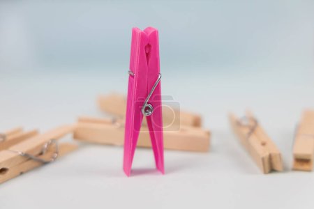 Photo for Pink clothespin on the background of ordinary wooden clothespins. The concept of being different, gender issue, standing out from the crowd, vision of man and woman. - Royalty Free Image