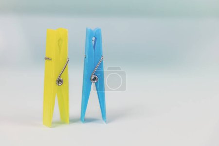 Photo for Blue and yellow clothespins. The concept of being different, gender issue, standing out from the crowd, vision of man and woman. - Royalty Free Image