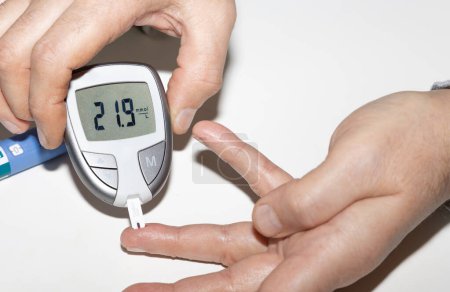 Diabetic man measuring blood sugar level. High blood sugar hyperglycemia. High quality photo