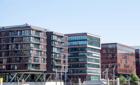 Téléchargez les photos : Façades de bâtiments modernes dans la ville de Hambourg en Allemagne. Hambourg par une journée ensoleillée. Quartier résidentiel de la ville. architecture moderne. Des maisons à étages. Immeuble. Louer un appartement. Tourisme en allemand. - en image libre de droit