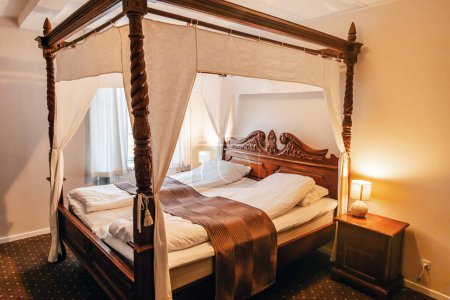Wooden four-poster bed in a hotel room. High quality photo