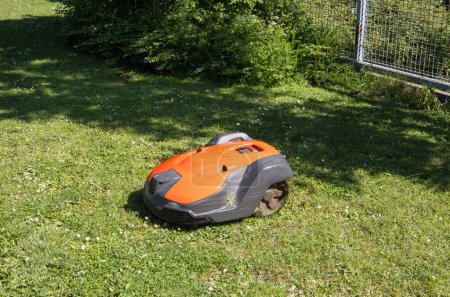 Foto de Cortacésped robótico en vista lateral de hierba. Robot para el jardín. Foto de alta calidad - Imagen libre de derechos