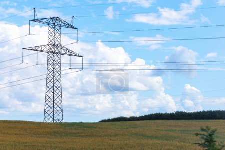Foto de Concepto de electricidad. Pilones de línea de alta tensión, torre eléctrica en un campo verde con cielo azul. Foto de alta calidad - Imagen libre de derechos