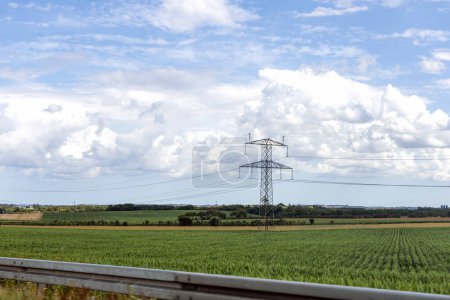 Foto de Concepto de electricidad. Pilones de línea de alta tensión, torre eléctrica en un campo verde con cielo azul. Foto de alta calidad - Imagen libre de derechos