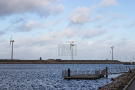 Wind turbine farm power genarator in beautiful nature landscape for production of renewable green energy. High quality photo