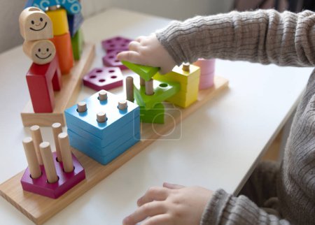 Foto de Niño jugando un divertido juego de lógica con bloques de madera de colores. Día y noche juego de lógica. Juegos educativos para niños y desarrollo temprano. - Imagen libre de derechos