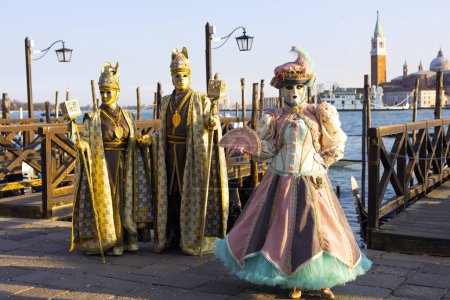 Téléchargez les photos : Venise, Vénétie, Italie - 19 février 2020 : Carnaval Mash vénitien artisanal posé sur le front de mer de la place Saint-Marc au coucher du soleil d'or Lumière chaude - en image libre de droit