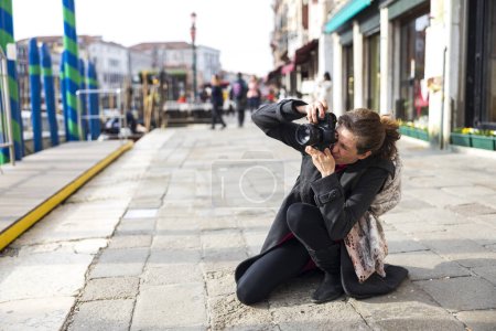 Foto de Turista fotógrafa caucásica adulta en Venecia tomando fotografías desde Sidewalk en Canal Grande - Imagen libre de derechos