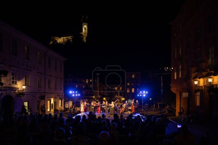 Photo for Ljubljana, Slovenia - September 15, 2021:Open classic concert by the river Ljubljanica in the old part of the old Ljubljana at evening hours with the castle well visible high in the sky. - Royalty Free Image