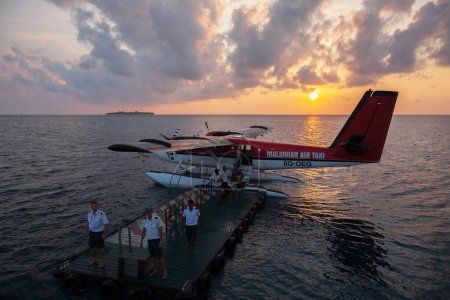Photo for Madoogali island, Maldives - March 15, 2010: Seaplane departure procedure at sunrise from a floating seaplane platform - Royalty Free Image