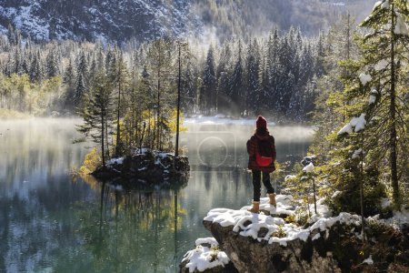 Photo for Woman Hiker Looking at Breathtaking View of Alpine Environment in Snowy Autumn Colours - Royalty Free Image