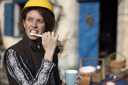 Téléchargez les photos : Brossage à dents le matin à l'extérieur pour une travailleuse agricole adulte moyenne - en image libre de droit