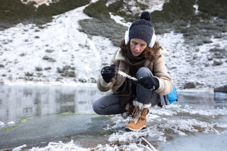 Foto de Expertise Mujer recogiendo muestras de heladas del lago congelado Medio ambiente en las altas montañas de los Alpes europeos - Imagen libre de derechos