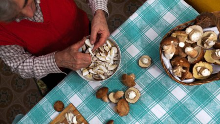 Photo for Housewife Scenting Fresh Mushrooms While Preparing them for Dinner - Royalty Free Image