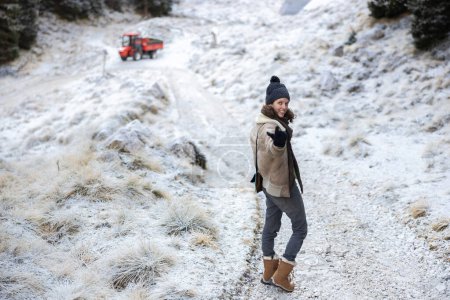 Téléchargez les photos : Femme mignonne en hiver Vintage Mountain Cloths in Follow Me - Venez avec moi geste sur un beau fond de paysage gelé Fermer - en image libre de droit