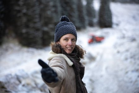 Téléchargez les photos : Femme mignonne en hiver Vintage Mountain Cloths in Follow Me - Venez avec moi geste sur un beau fond de paysage gelé Fermer - en image libre de droit