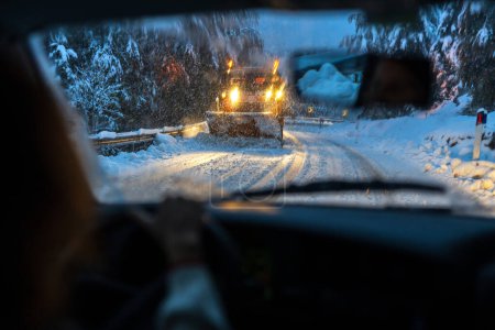 Téléchargez les photos : À travers les yeux d'un conducteur assidu, manœuvrant sur des routes glissantes, glacées, enneigées et imprévisibles sur le chemin du travail - en image libre de droit