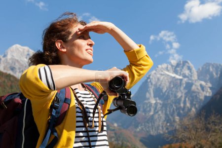 Téléchargez les photos : Serene Brunette Mid Adult Femme Touriste Profitant Voyage dans les montagnes et regardant vers l'avenir pour l'aventure - en image libre de droit