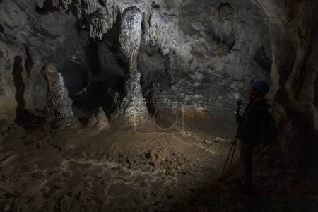Photo for Speleologist Admiring with Help of a Light Stalactites and Stalagmites in Underground World Panorama of Zaleske Caves in Rakov Skocjan Slovenia Europe - Royalty Free Image
