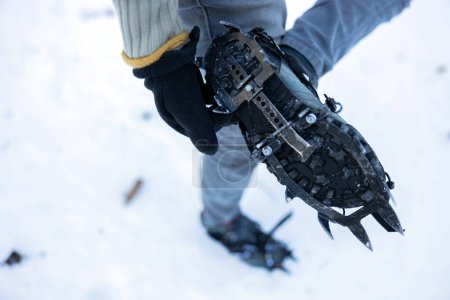 Photo for Close up from a Personal Perspective of Winter Walking Equipment - Crampons on Hiking Boots - Royalty Free Image