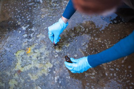 Foto de Trabajador ambiental toma muestras de agua biológicamente contaminada para análisis - Imagen libre de derechos