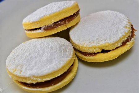 Photo for Alfajores: sweet cookies filled with milk caramel or  dulce de leche, dusted with powdered sugar. Soft and tempting, with an irresistibly appetizing appearance. - Royalty Free Image