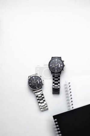 Foto de Cuadernos en blanco y negro con relojes sobre fondo blanco - Imagen libre de derechos