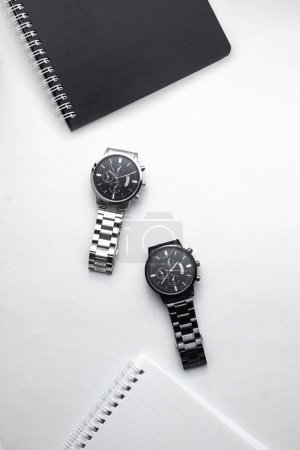 Foto de Vista superior de cuadernos en blanco y negro con reloj de pulsera en superficie blanca. plano, vista superior - Imagen libre de derechos