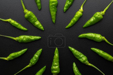 Téléchargez les photos : Piments verts frais sur fond noir - en image libre de droit