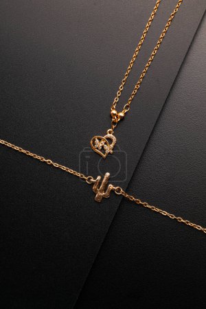 Foto de Pulsera y collar de oro de lujo con colgante de corazón, tiro al estudio - Imagen libre de derechos