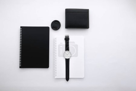 Foto de Reloj de cuero negro en escritorio blanco con negro y portátil - Imagen libre de derechos