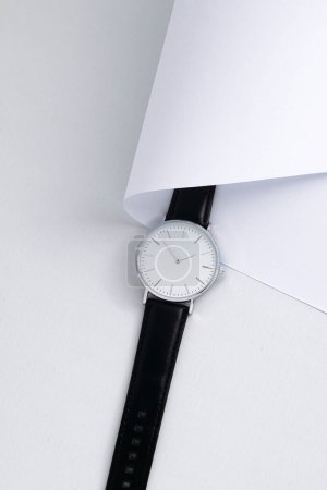 Photo for Black leather watch on white work desk with white paper - Royalty Free Image
