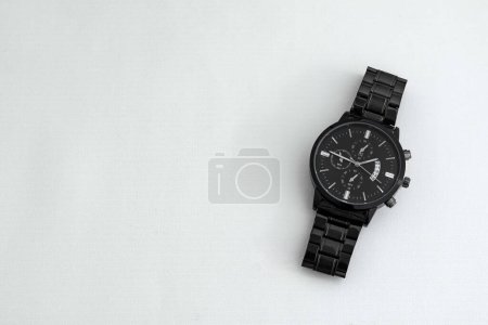 Luxury black men's watch on white table. Monochromatic concept. Complementary color concept.