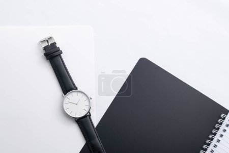 Téléchargez les photos : Montre en cuir noir sur bureau blanc avec ordinateur portable noir - en image libre de droit