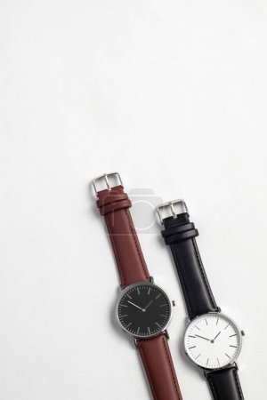 Foto de Relojes con correa de cuero marrón y negro en escritorio de oficina blanco - Imagen libre de derechos