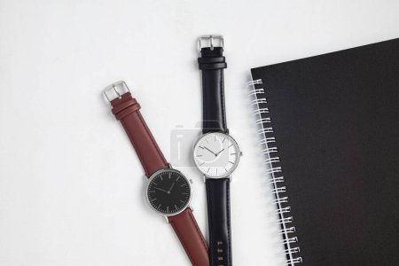 Foto de Relojes con correa de cuero marrón y negro en escritorio de oficina blanco - Imagen libre de derechos