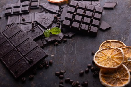 Foto de Dark, milk and nut chocolate bars. Crumbled on scattered cocoa. - Imagen libre de derechos