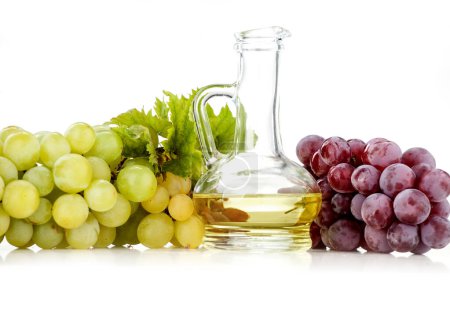 Foto de Uvas frescas en cesta con aceite de semilla de uva - Pura elegancia para su salud Productos de uva premium sobre fondo blanco - Imagen libre de derechos