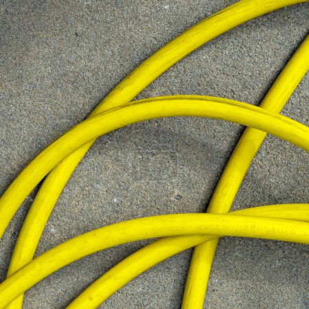 Photo for Yellow hose on asphalt, from above, square type. High quality photo. Aerial view - Royalty Free Image