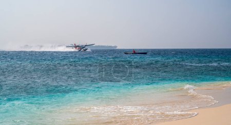 Photo for The seaplane takes off on the sea surface and swirls the water. Blue sky. - Royalty Free Image