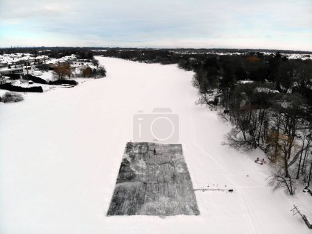 Vista aérea de una pista de patinaje sobre un río congelado en pleno invierno