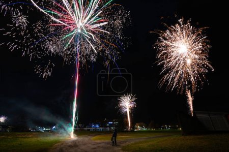 Photo for Me and my son standing still and careful watching fireworks from the distance and celebrating the new year 2024. The explosions were realy spectacular and we had a great view of the light show - Royalty Free Image
