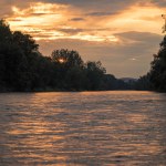 A sunset, the river Mura in nature with a cloudy sky