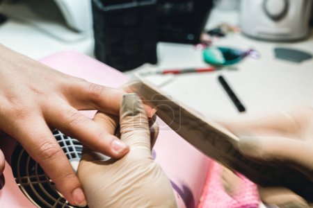 Foto de Una manicura haciendo una manicura a una mujer en su salón de manicura - Imagen libre de derechos